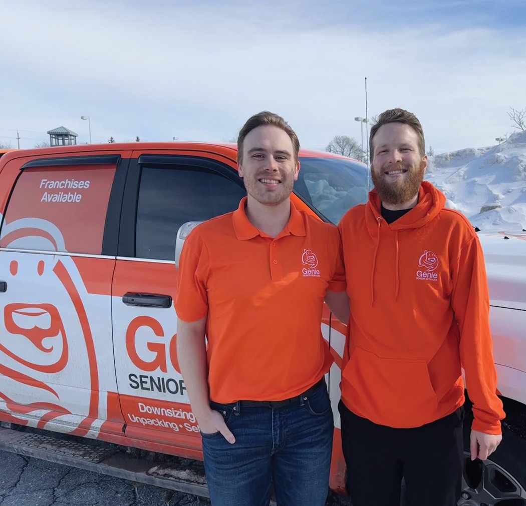 Ethan and Jonathan, co-founders of Genie Senior Services, standing in front of their Genie-branded vehicle